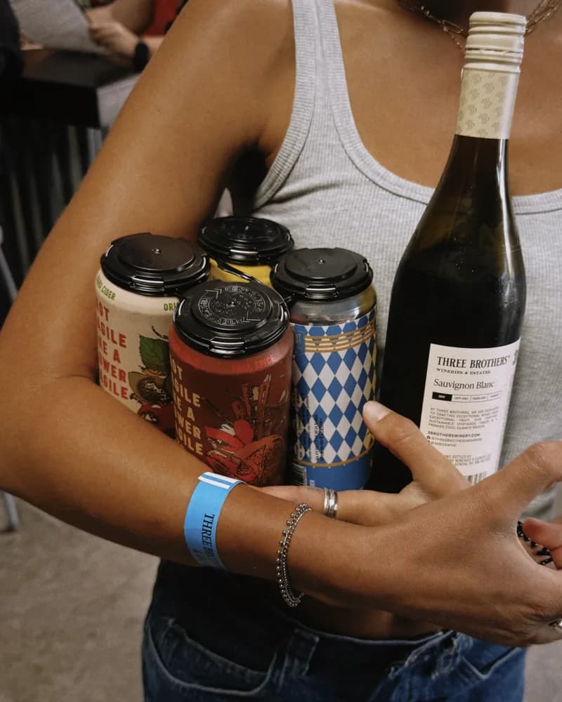 A shopper carrying craft cans and a bottle of wine