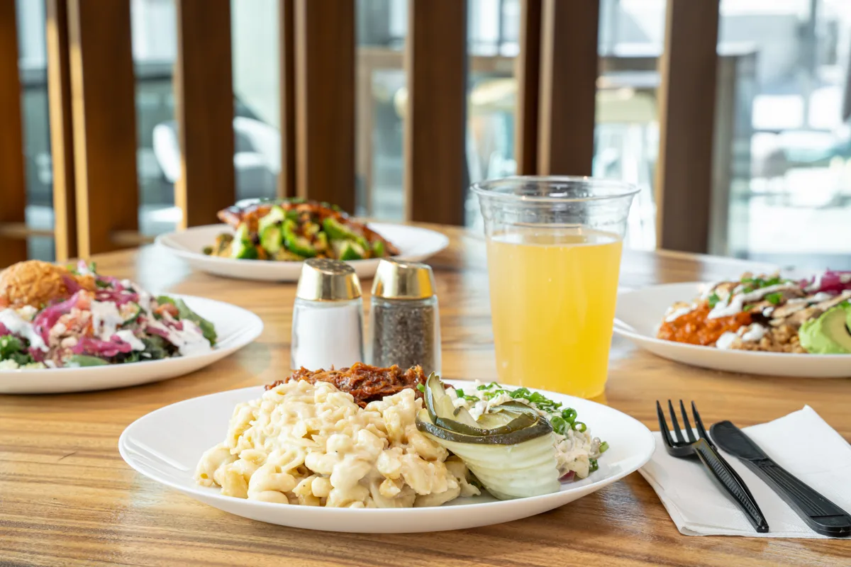 A table set with Savi bowls, salads and a fresh drink