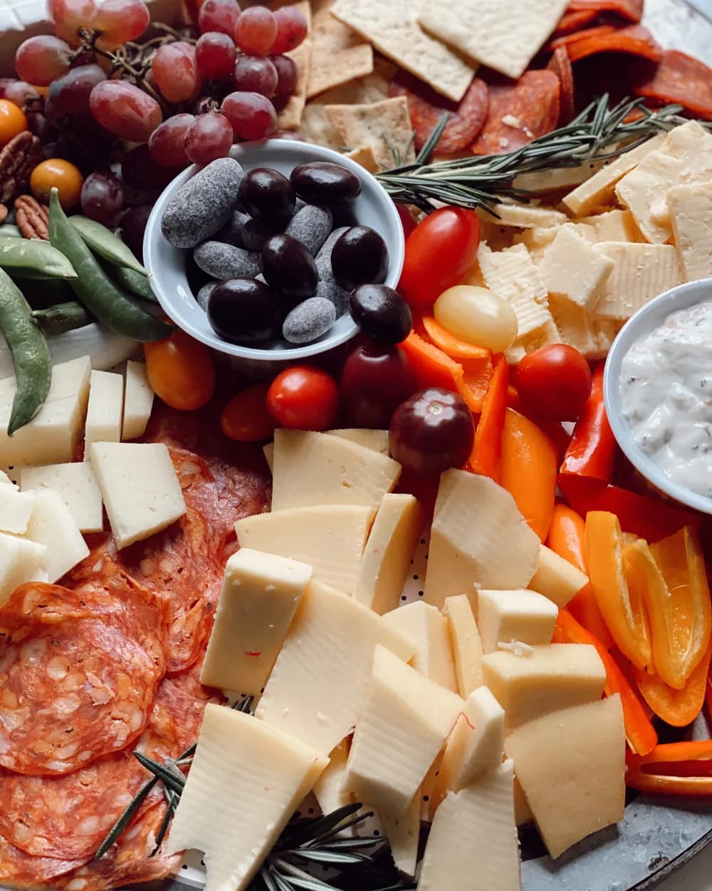 A Savi catering board of cheeses, charcuterie and fresh vegetables