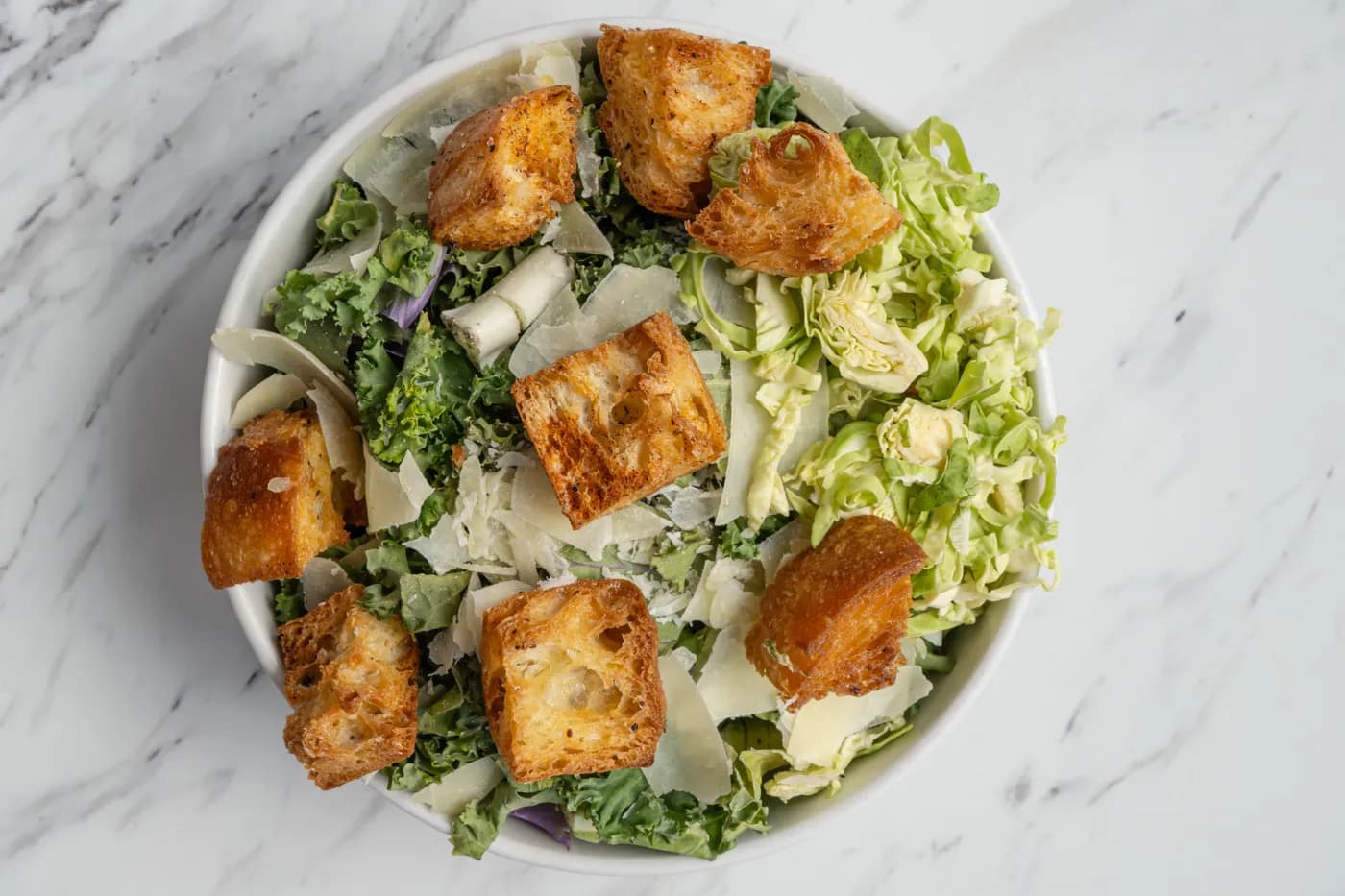 A kale caesar salad packed and ready to go